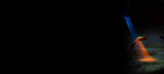 Jeweler soldering on work bench a gold ring bracelet with flame from welding torch in an authentic jewelry workshop