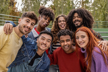 Happy playful multiethnic group of young friends standing together outdoors - multiracial millennial students meeting in the city, concepts of youth, people lifestyle, diversity - obrazy, fototapety, plakaty