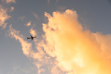 Airplane flying on blue sky with clouds.