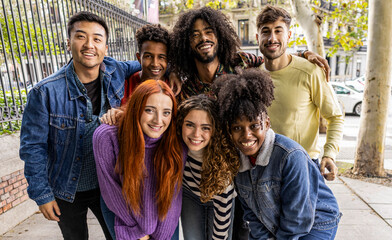 Diverse group of happy young best friends having fun taking selfie photos together - International...