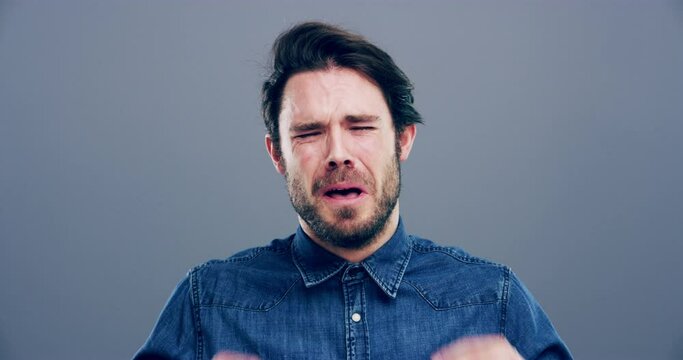 Psychology, crying and young man in a studio with upset, worry and depression face expression. Emotions, grief and male person from Canada with tears for broken heart isolated by gray background.