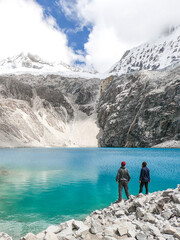 casal de braços erguidos em frente a laguna 69, no parque nacional huascarán, no peru 