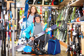 Woman and man are demonstrating their choice of ski boots - obrazy, fototapety, plakaty