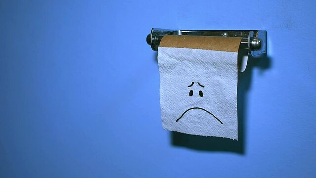 Medium, low angle, lonely, sad face on last piece of toilet paper/tissue on a brown cardboard roll, lightly moving in the breeze, blue wall, copy space