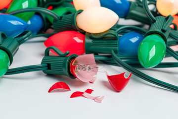 Broken bulb in Christmas string lights. Holiday lighting repair, safety and decoration concept.