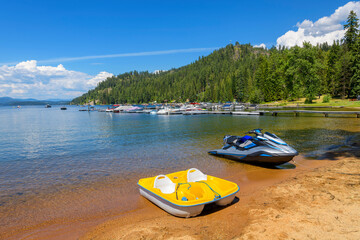 A paddle boat and wave runner on the beach at the lakefront resort and marina at Cavanaugh Bay in...