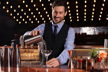Bartender preparing fresh alcoholic cocktail in bar