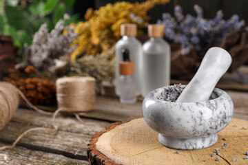 Mortar with pestle and lavender flowers on wooden table, space for text. Medicinal herbs