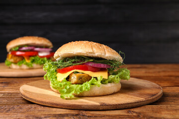 Delicious burgers with tofu and fresh vegetables on wooden table