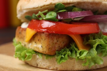Delicious burger with tofu and fresh vegetables on board, closeup