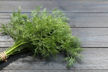 Bunch of fresh green dill on grey wooden table, closeup. Space for text