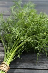 Bunch of fresh green dill on grey wooden table, closeup