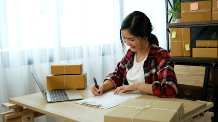 Online seller Close up hands Young asian woman typing laptop keyboard checking online order, check goods stock delivery package shipping postal. Asian woman startup small business at home office