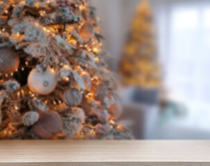 Wooden table near beautifully decorated Christmas tree. Space for design