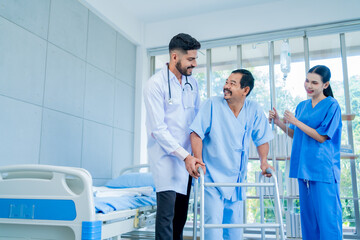 A Muslim male doctor and nurse help a patient who is doing physical therapy and is practicing walking with a walking stick.