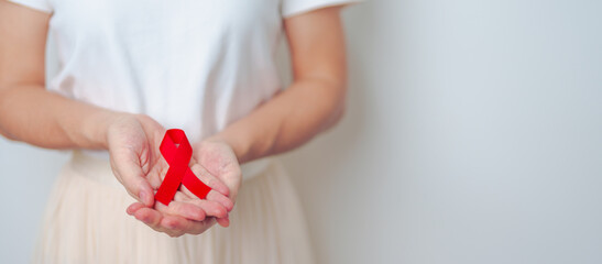 woman with Red Ribbon for December World Aids Day, acquired immune deficiency syndrome, multiple myeloma Cancer Awareness month and National Red ribbon week. Healthcare and world cancer day concept - obrazy, fototapety, plakaty