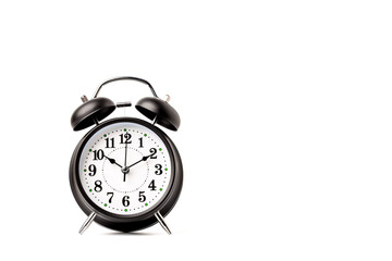 Antique black alarm clock with white dial. isolated on a white background.