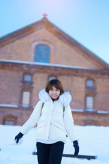 Woman tourist Visiting in Sapporo, Traveler in Sweater looking Sapporo Beer Museum with Snow in...