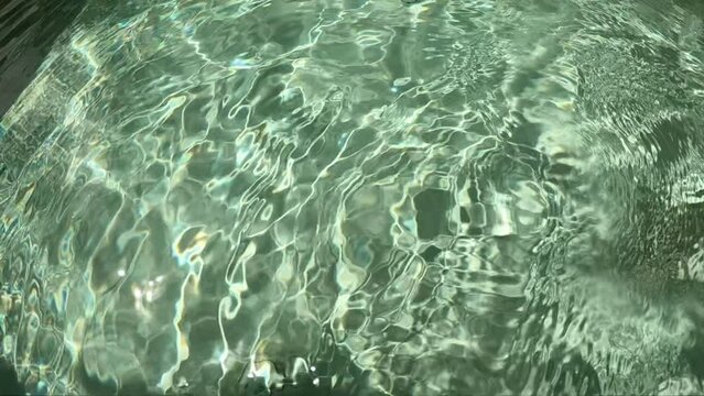 water wave of outdoor swimming pool, the sun's ray pass through the water slow motion scene