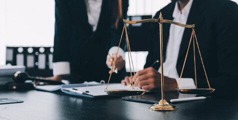 Business and lawyers discussing contract papers with brass scale on desk in office. Law, legal services, advice, justice and law concept picture with film grain effect