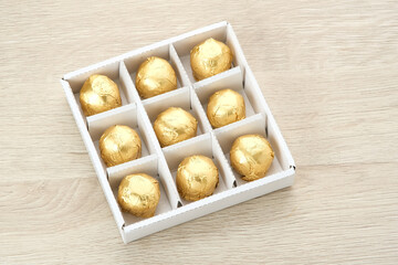 Chocolate candies with dates fruit filling in a box. Gifts festive food love concept.
