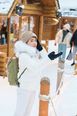 Woman tourist Visiting in Furano, Traveler in Sweater sightseeing Ningle Terrace Cottages with Snow in winter. landmark and popular for attractions in Hokkaido, Japan. Travel and Vacation concept