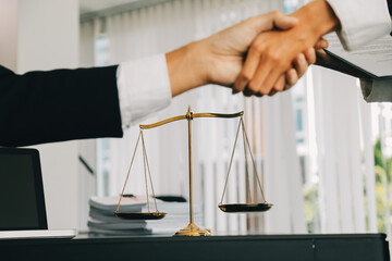 Businessman shaking hands to seal a deal with his partner lawyers or attorneys discussing a...