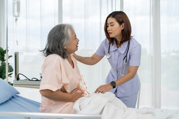 A nurse or caregiver for an elderly patient is helping a patient with severe stomach problems