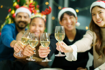 Group of diverse ethnicity young people enjoy celebrating a Christmas and New Year party together with a lot of foods and drinks. Friends celebrate Christmas and New Year festival and drink a wine.
