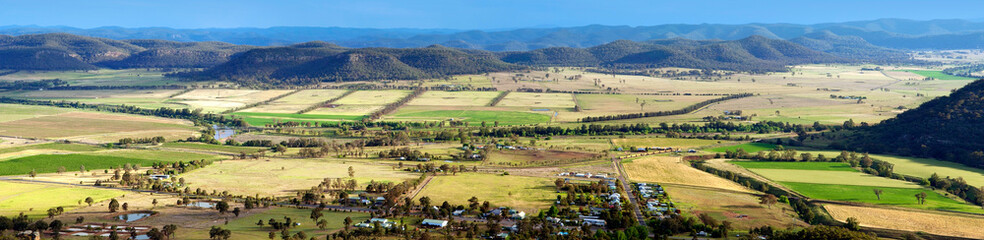 Obraz premium Aerial panorama of Australian rural farmland with a small town and mountains in New South Wales