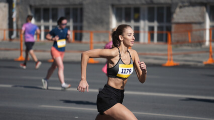 Female jogger run marathon. Thin girl work out. Woman runner jog long distance. Finish line road....
