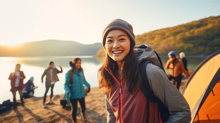 Smiling Asian female tourist brings family Camping by the lake. - obrazy, fototapety, plakaty