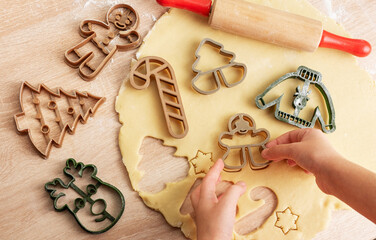 Children's hands with gingerbread cookies on wooden background