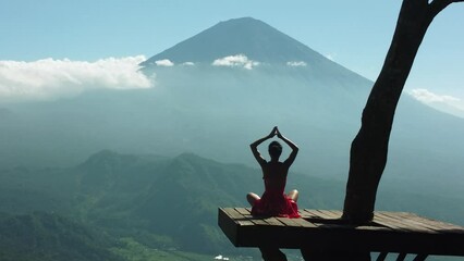 Aerial 4K Drone Footage: Serene Yoga at Lahangan Sweet, East Bali; Girl in Anjali Mudra Pose on Tree Platform, Gazing at Agung Volcano; Ideal for Wellness Blogs, Meditation, and Travel Videos