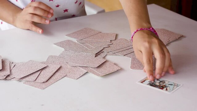 Woman&rsquo;s hands spreading tarot cards, sliding them and picking random one