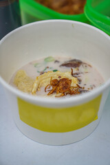 Betawi coconut milk soto is in a paper bowl