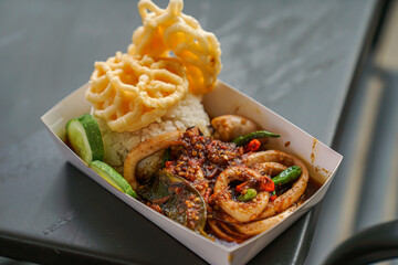 Fried squid sauce with rice, crackers and cucumber