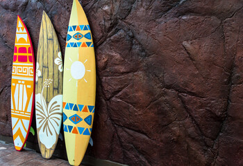 Flashy pattern surfboard against the rock wall.