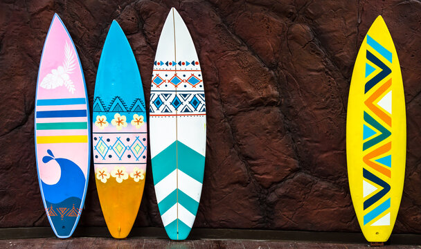 Flashy pattern surfboard against the rock wall.
