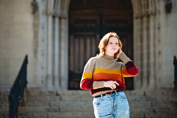 Fototapeta premium Beautiful teen girl standing in front of cathedral steps, backlit.