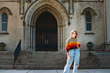 Fototapeta na wymiar Pretty teen girl standing in front of cathedral church steps.