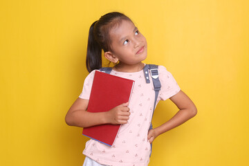 School girl, Happy Asian student school kid with backpack, holding book and looking up thinking