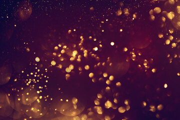 Fototapeta na wymiar Golden abstract bokeh on black background. Celebrating Christmas, New Year or other holidays.