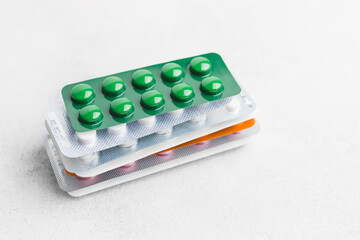 Pile of various pills and tablets in a blister pack on white background, healthcare and medicine concept