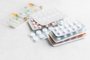 Pile of various pills and tablets in a blister pack on white background, healthcare and medicine concept
