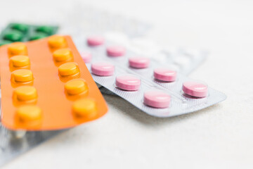 Pile of various pills and tablets in a blister pack on white background, healthcare and medicine concept