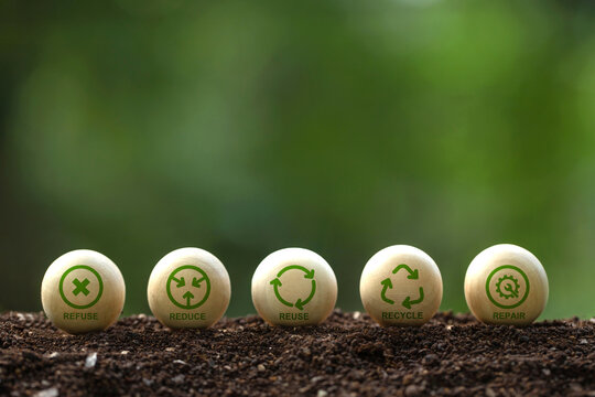 5R icons on wooden sphere balls on a green background. Recycle,
