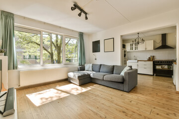 a living room with wood flooring and large windows looking out onto the trees in the area is very...