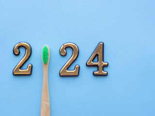 2024 and dental concept. Close up view photo with 2024 and wooden green toothbrush instead zero on...