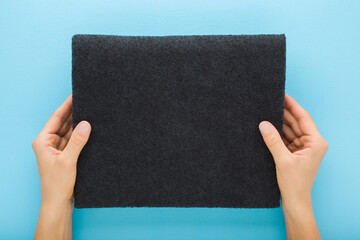 Young adult woman hands holding and showing new dark black charcoal filter for kitchen cooker hood...